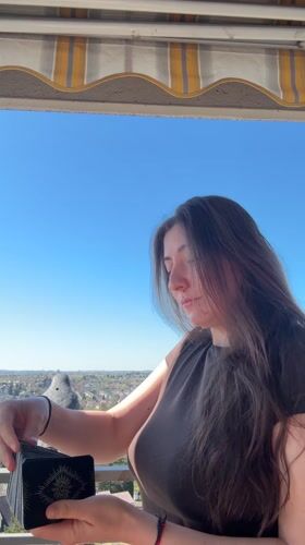 Woman draws tarot cards on sunny balcony in Waiblingen