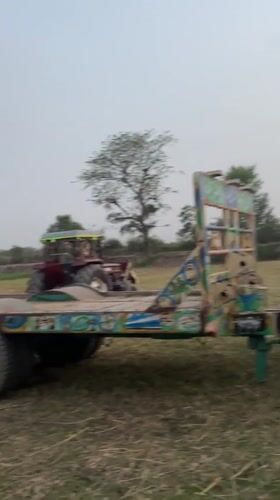 Farm workers harvest grain with tractors in Parwanwala Pakistan