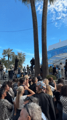 Crowd gathers outside modern building in Cannes