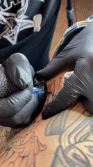 Tattoo artists work on clients at Buenos Aires studio