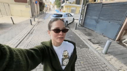 Woman takes selfies on cobblestone street in Jaffa, Tel Aviv