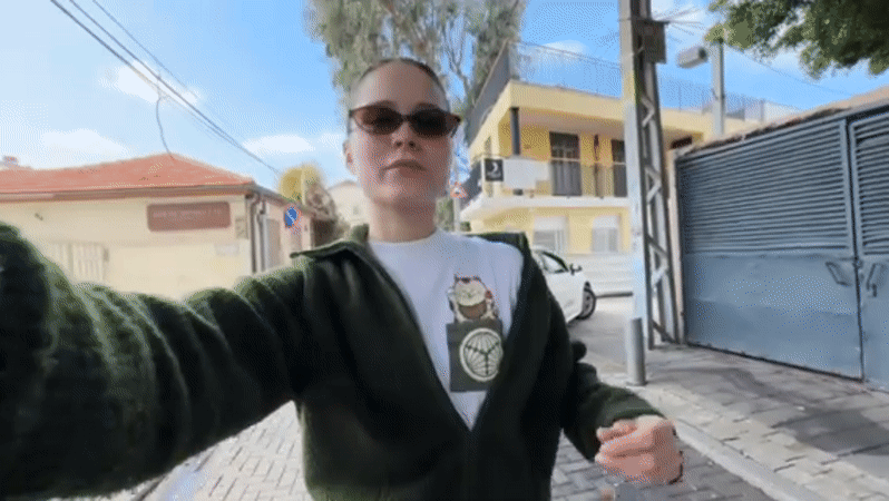 Woman takes selfies on cobblestone street in Jaffa, Tel Aviv