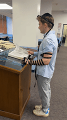 Young man conducts morning prayers at NYC synagogue