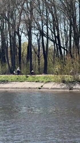 Spring day captured along tree-lined waterway in Dmitrov, Russia