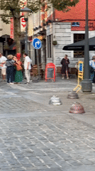 Cobblestones, red bollards, and a statue in Liège