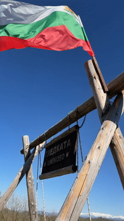 Visitor documents scenic mountain viewpoint with swing set in Shipkovo