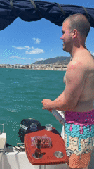 Man opens champagne on boat in Torremolinos waters