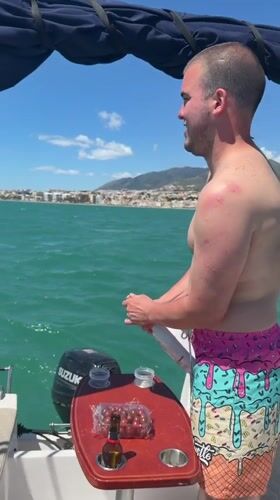 Man opens champagne on boat in Torremolinos waters