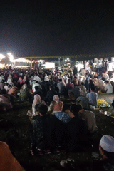 Nighttime outdoor gathering with stage and crowd in Rembang