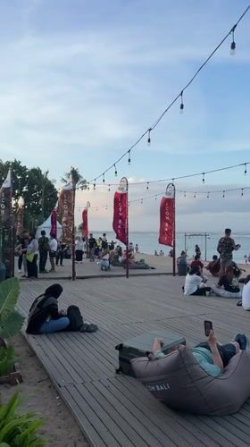 Morning beach activity captured across Denpasar boardwalk and restaurants