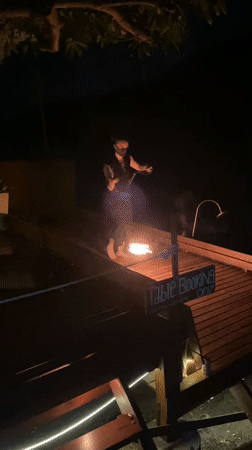 Fire dancers perform at nighttime beach party in Thailand