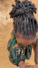 Nigerian village children play with pet monkey in yard
