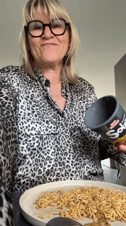 Woman enjoys instant noodles in French village