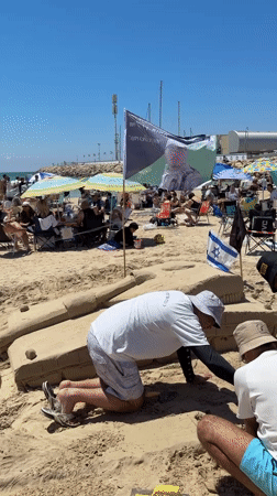 Three People Build Sand Fortification on Herzliya Beach
