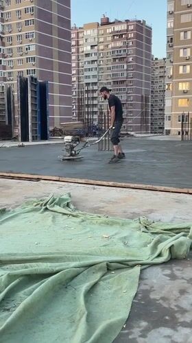 Worker operates power trowel on concrete slab in Krasnodar