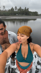 Couple takes selfie at black sand beach in Indonesia