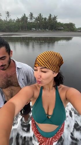 Couple takes selfie at black sand beach in Indonesia