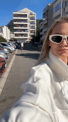 Woman in white outfit walks, takes selfies in Budva