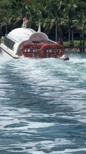 White passenger boat departs green shoreline in Nha Trang