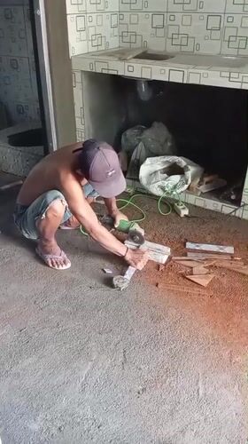 Construction worker cuts materials with grinder in Baron, Indonesia