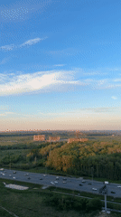 Highway corridor through forest captured with construction, parking visible