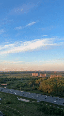 Highway corridor through forest captured with construction, parking visible