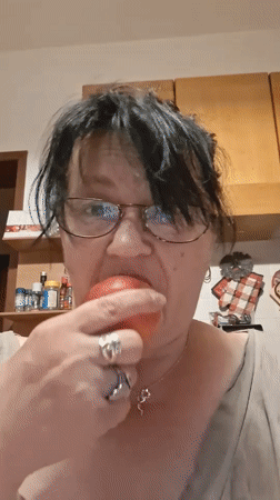 Woman enjoys fruit, poses playfully in Colorno evening