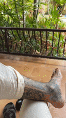 Person with leg tattoo sits in Pattaya morning scene