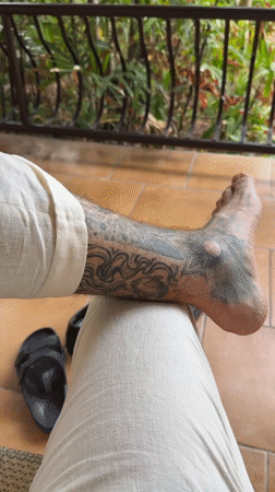 Person with leg tattoo sits in Pattaya morning scene