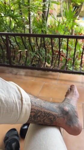 Person with leg tattoo sits in Pattaya morning scene