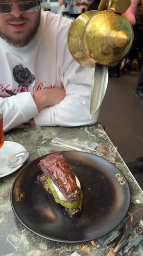 Person adds cream to baklava at Istanbul cafe