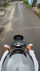Motorcyclist travels narrow road in Kuta Selatan, Indonesia