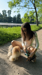 Woman photographs Pomeranian dog during sunny park outing