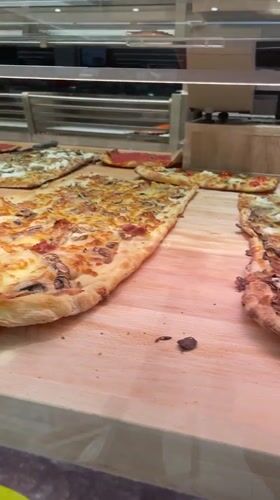 Pizza al taglio displayed at Roman establishment