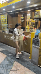 Women use charging station on Tianhe District sidewalk