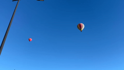 Hot air balloons rise over Arroyo de la Encomienda at dawn