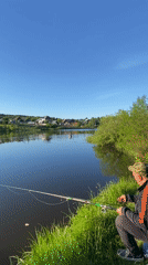 Adult and child fishing at pond in Markovo, Russia