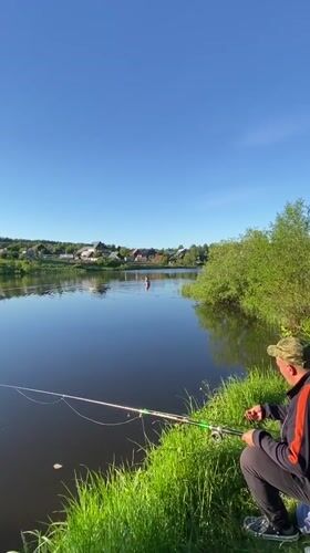 Adult and child fishing at pond in Markovo, Russia