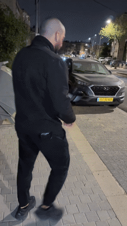 Man performs martial arts on Jerusalem street at night