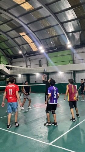 Evening volleyball game observed in Wilde, Argentina gymnasium