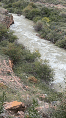 Turbulent river canyon and yurts in Central Asian mountain terrain