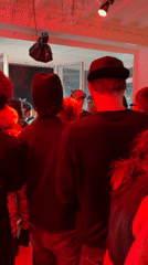 Indoor party with red lighting draws crowd in Palaiseau