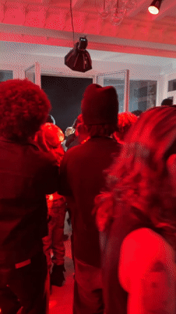 Indoor party with red lighting draws crowd in Palaiseau