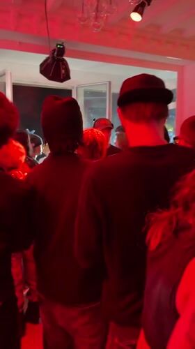 Indoor party with red lighting draws crowd in Palaiseau