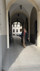 Woman in checkered shirt walks through Riga archway