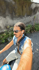 Man in denim vest rides blue scooter in North Kuta