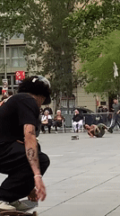 Skateboarder practices tricks in Barcelona public square during evening