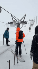 Three skiers prepare for lift ride in Kutchan