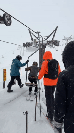 Three skiers prepare for lift ride in Kutchan