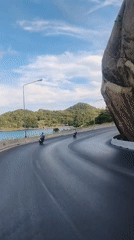 Motorbike riders travel scenic coastal road in Thailand